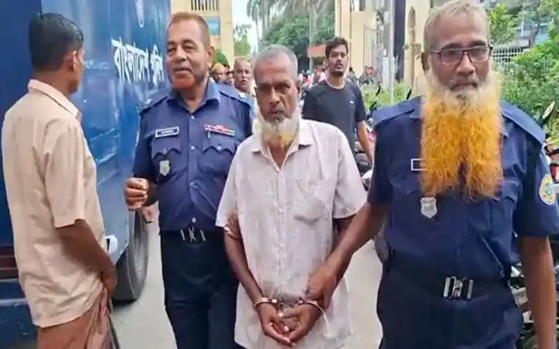 আদালত থেকে বের হচ্ছেন একজন আসামি, পুলিশ সদস্যরা পাশে রয়েছেন।. Channel i News - চ্যানেল আই নিউজ