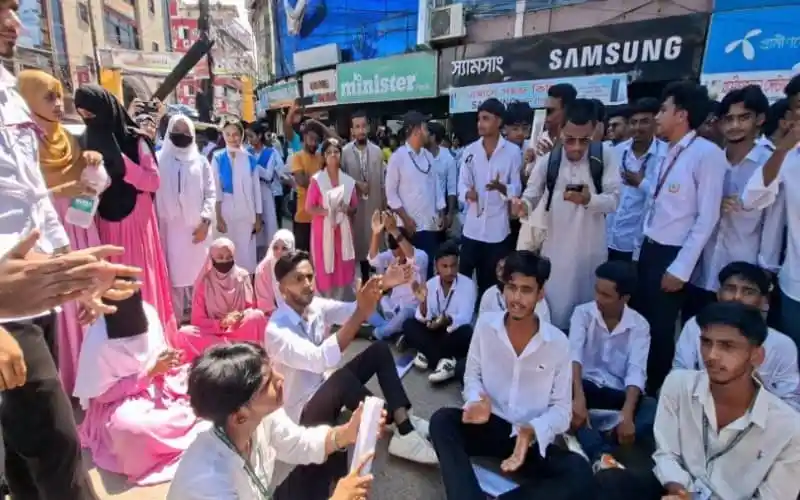 Bangladeshi students protesting on the street with banners and police presence. Channel i News - চ্যানেল আই নিউজ