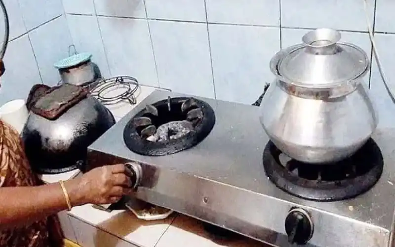 Gas stove with a large metal pot and a smaller container on top, in a kitchen setting. Channel i News - চ্যানেল আই নিউজ