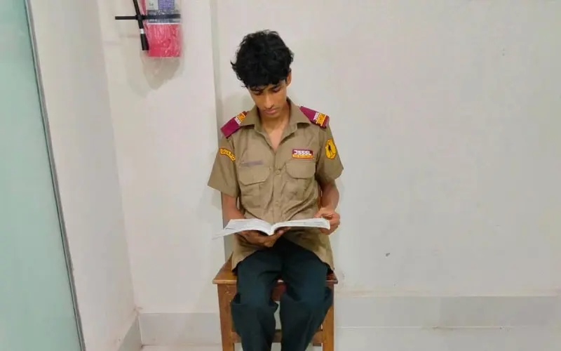 ছাত্রটি স্কুলের uniform পরে বই পড়ছে. Channel i News - চ্যানেল আই নিউজ