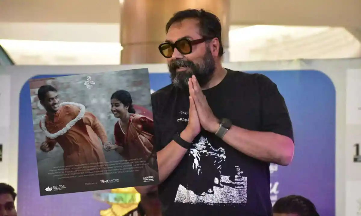 Filmmaker holding a poster at a promotional event in Bangladesh. Channel i News - চ্যানেল আই নিউজ
