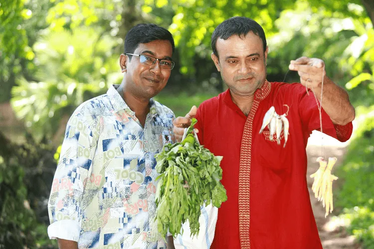 দুই ব্যক্তি বনজীবী, একজন শাকসবজি দেখাচ্ছেন অন্যজনের. Channel i News - চ্যানেল আই নিউজ