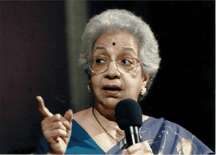 বিজয়া মেহতা বক্তৃতা দিচ্ছেন, প্যাঁচানো চুল ও সোনালী গহনা পরা. Channel i News - চ্যানেল আই নিউজ