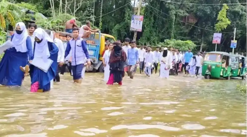 শিক্ষার্থীরা বন্যার পানিতে হাঁটছে চট্টগ্রামে।. Channel i News - চ্যানেল আই নিউজ