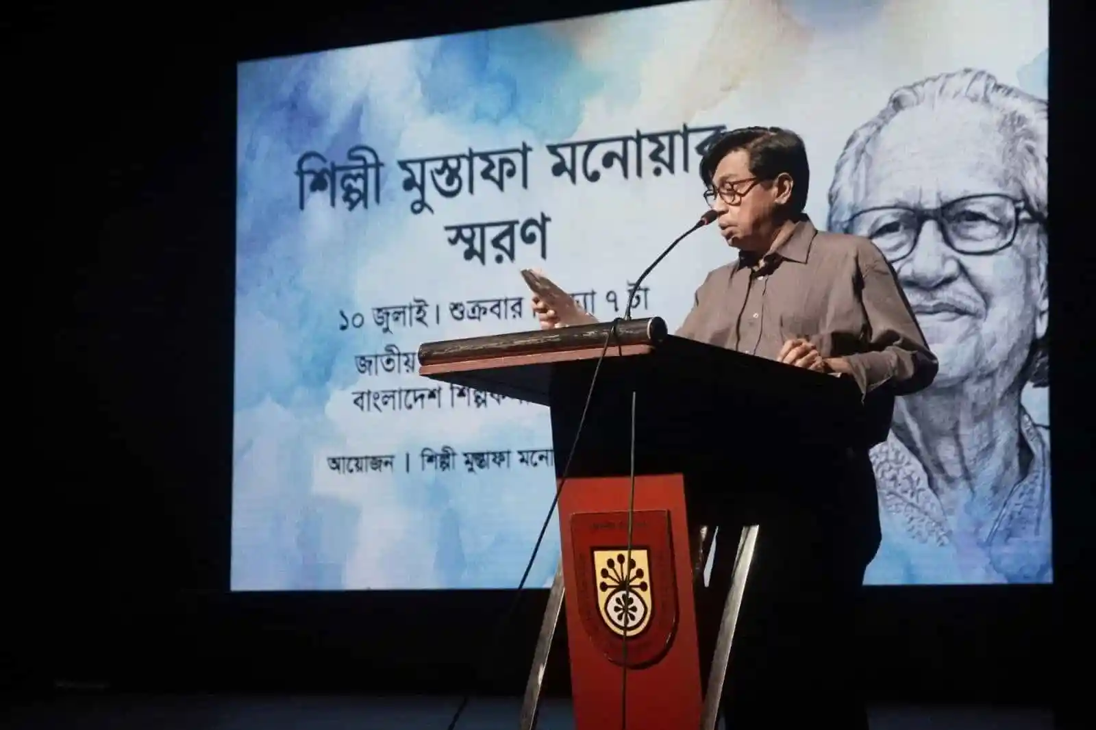 শিল্পী মুস্তাফা মনোয়ারের স্মরণে বক্তৃতা দিচ্ছেন একজন ব্যক্তি. Channel i News - চ্যানেল আই নিউজ