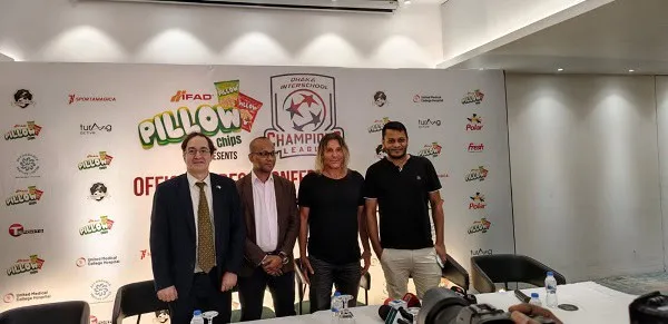 চারজন ব্যক্তি একটি টেবিলের পাশে দাঁড়িয়ে আছেন, পেছনে ব্যানার রয়েছে।. Channel i News - চ্যানেল আই নিউজ