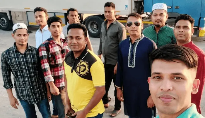 বাংলাদেশি যুবকদের একটি দল ছবি, তারা ট্রাকের পাশে দাঁড়িয়ে আছে. Channel i News - চ্যানেল আই নিউজ