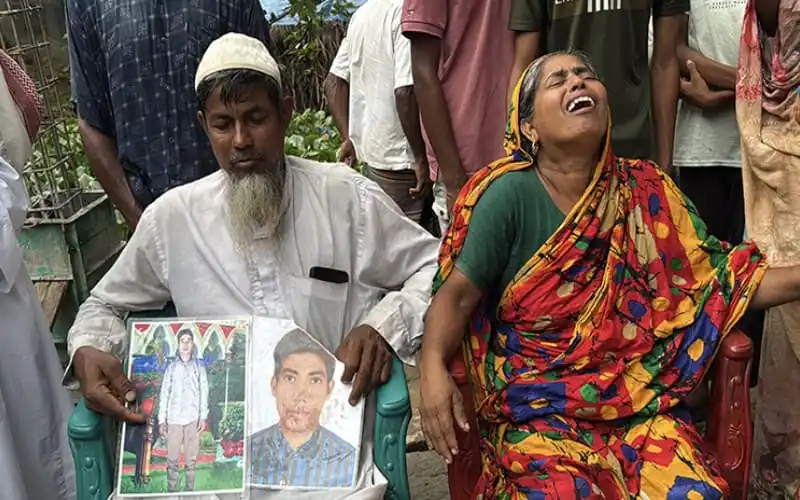 দুজন শোকাহত ব্যক্তি, একজন কাঁদছেন, অন্যজন ছবি ধরে আছেন, শোকের মুহূর্তে. Channel i News - চ্যানেল আই নিউজ