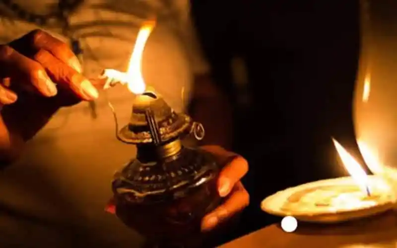 বিদ্যুৎ বাতি জ্বালানোর জন্য মোমবাতি ব্যবহার করছে একজন ব্যক্তি. Channel i News - চ্যানেল আই নিউজ