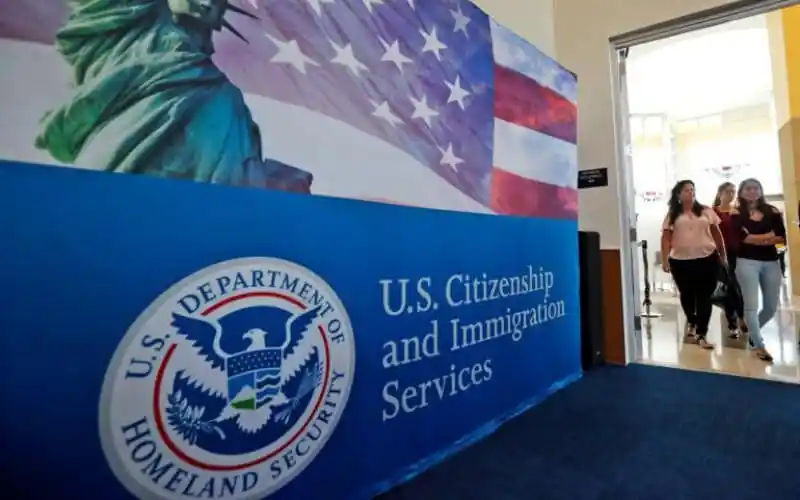 U.S. Citizenship and Immigration Services অফিসের প্রবেশদ্বার, আমেরিকার পতাকা ও মার্কিন যুক্তরাষ্ট্রে. Channel i News - চ্যানেল আই নিউজ
