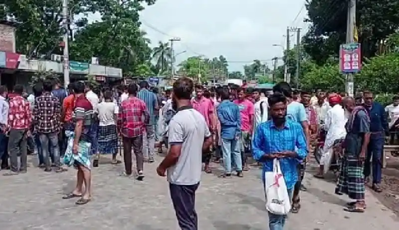 জনসমাগমের মধ্যে একাধিক মানুষ রাস্তার পাশে দাঁড়িয়ে রয়েছে. Channel i News - চ্যানেল আই নিউজ