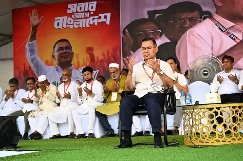প্রধানমন্ত্রী জনসভায় বক্তৃতা দিচ্ছেন, পাশে অন্যান্য নেতা ও কর্মীরা. Channel i News - চ্যানেল আই নিউজ