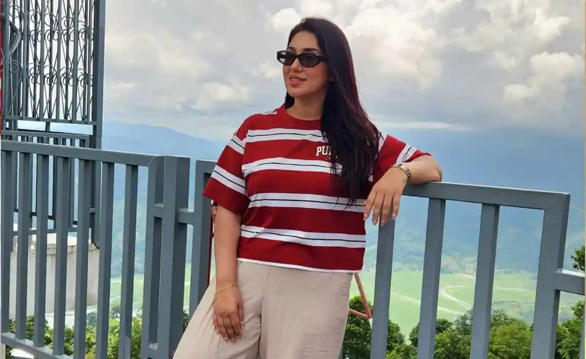 অপু বিশ্বাস পাহাড়ের দৃশ্যের পাশে সানগ্লাস পরে হাসিমুখে দাঁড়িয়ে. Channel i News - চ্যানেল আই নিউজ