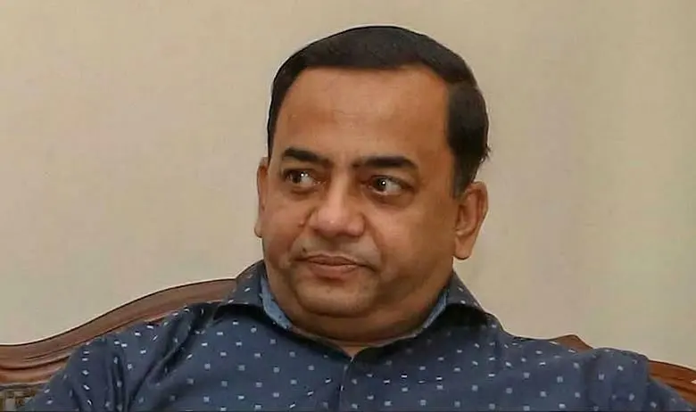Benazir in a formal setting, wearing a blue shirt with white dots. Channel i News - চ্যানেল আই নিউজ