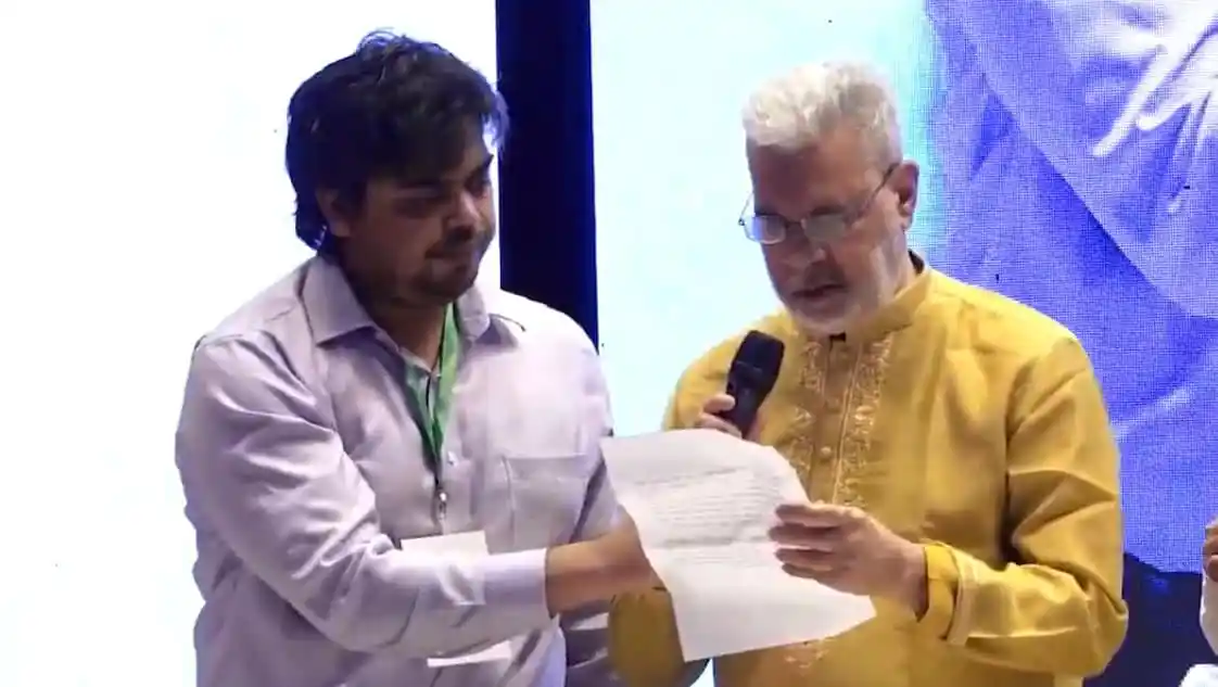 ইলিয়াস কাঞ্চনের আবেগঘন বক্তব্যের সময় ছবি, দুই ব্যক্তি হাতে নথিপত্র দেখছেন. Channel i News - চ্যানেল আই নিউজ