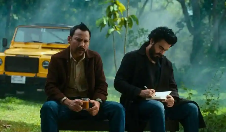 দুই ব্যক্তি বনাঞ্চলে বসে চা পান ও নোটবুক লিখছেন. Channel i News - চ্যানেল আই নিউজ